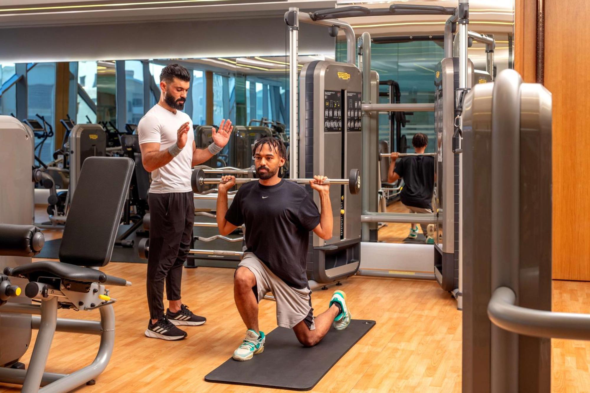 Hyatt Regency Riyadh Olaya Екстер'єр фото Personal trainer coaching a man on a Bulgarian split squat